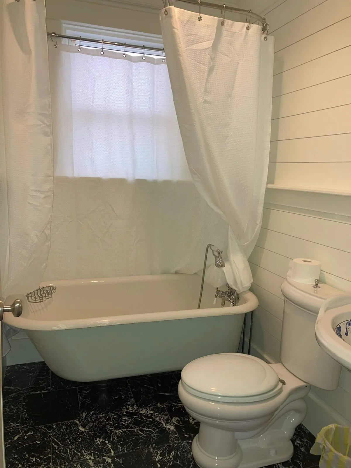 A beautifully updated bathroom featuring a large bathtub, sleek sink, and toilet. The space feels tranquil and is ideal for self-care rituals like soaking after a long day or refreshing morning routines.
